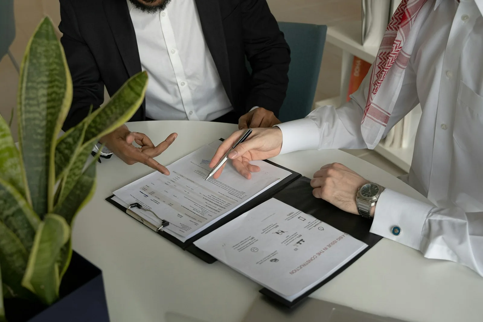 Two people reviewing and signing documents at a table