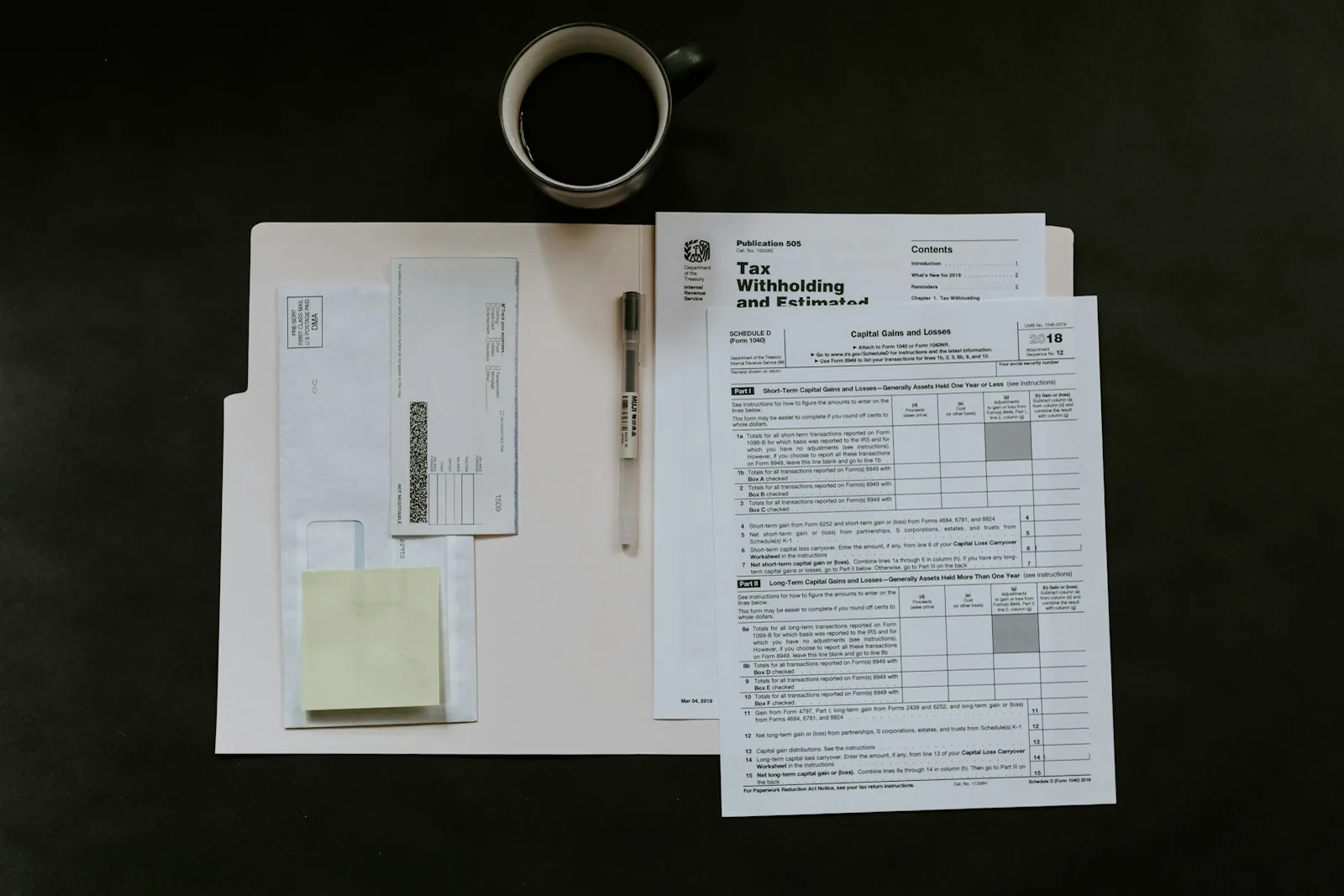 Tax forms, a pen and a cup of coffee on a desk