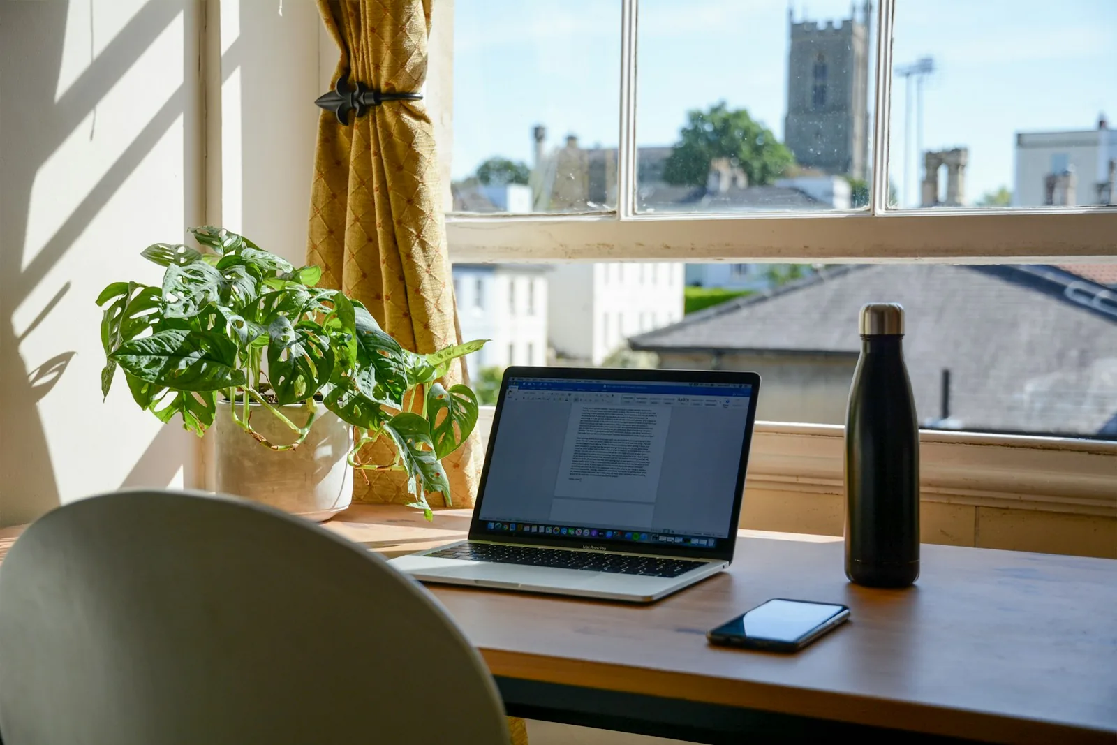 Laptop on a desk by the window: working remotely from Spain for a foreign employer